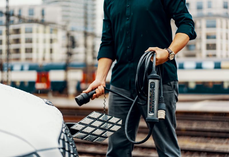 A Man Using J+ BOOSTER Portable EV Charger